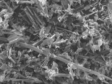 Microscopic image of mineral particles displaying various crystalline structures, captured at 250x magnification. The image highlights the intricate details and textures of the sample, useful for geological and material science studies.