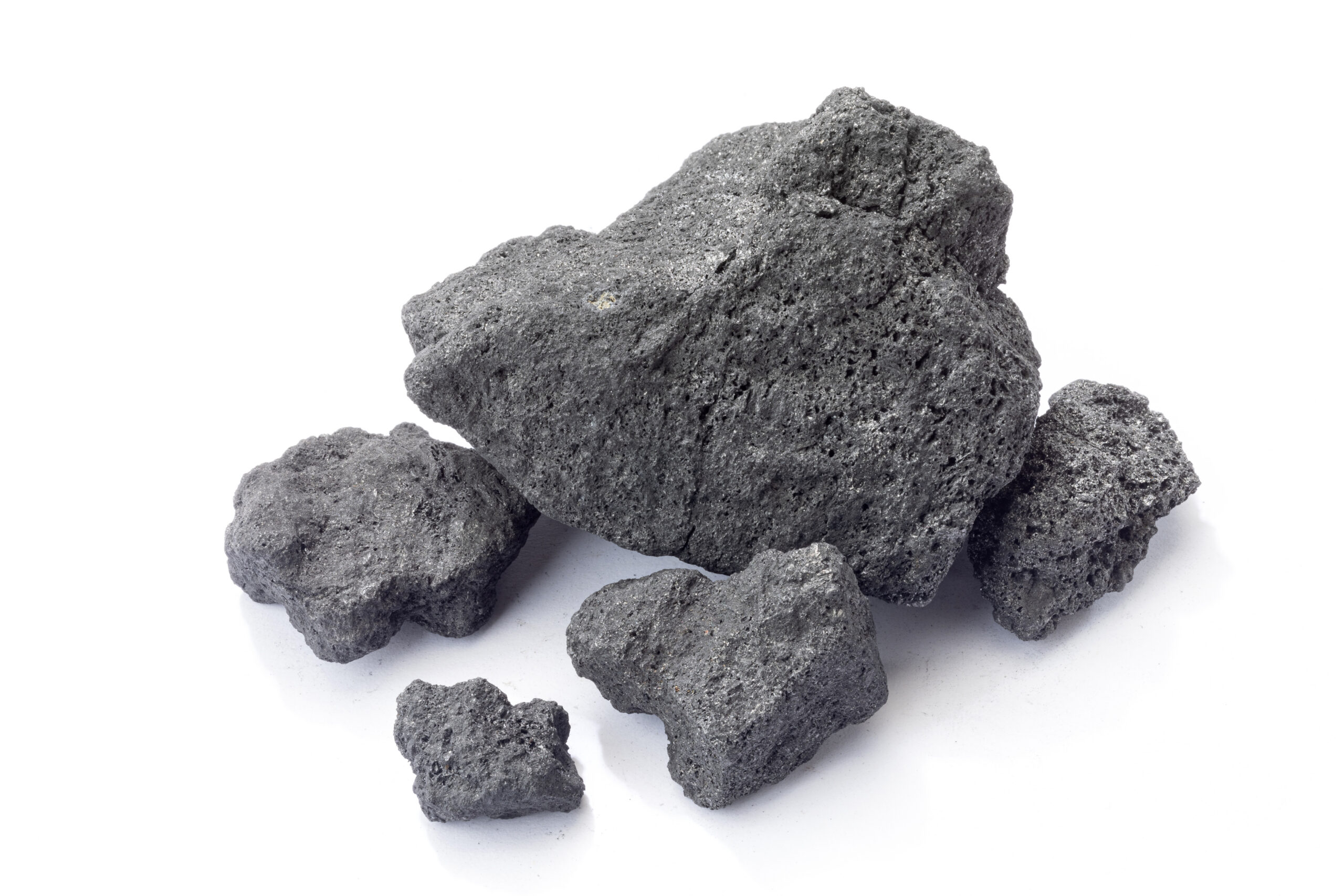 Close-up of various pieces of volcanic rock, showcasing their rough texture and dark gray color, ideal for landscaping and natural stone applications.