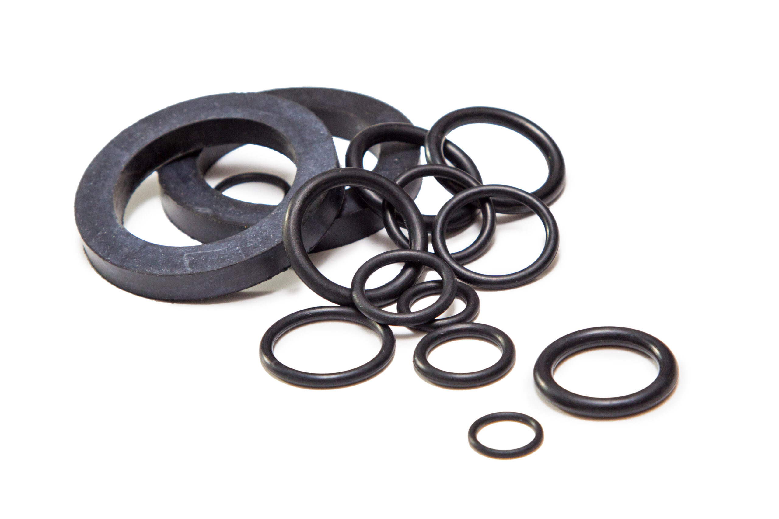 A collection of various sizes of black rubber O-rings and washers, commonly used for sealing and preventing leaks in mechanical applications.