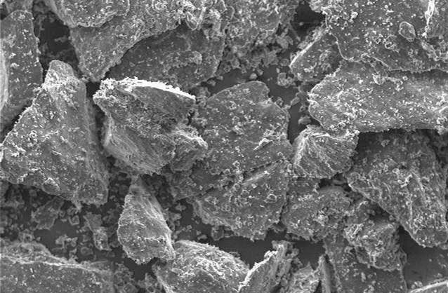 Microscopic image of mineral fragments showcasing varied shapes and textures, highlighting the intricate details of the surface structure. Suitable for studies in geology or material science.