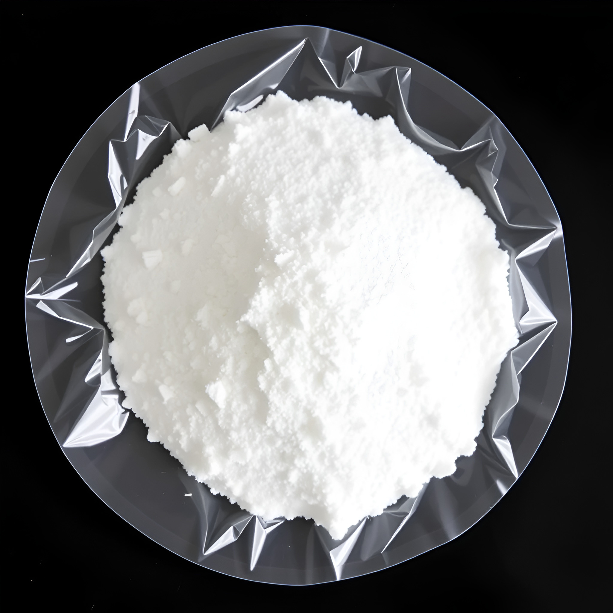 White crystalline substance in a plastic dish, commonly used for industrial or laboratory applications. The texture appears fine and powdery, indicating high purity.