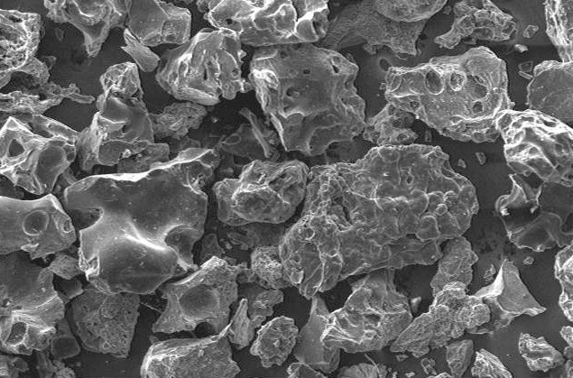 Microscopic view of irregularly shaped particles showing detailed textures and structures, suitable for studies in materials science and nanotechnology.