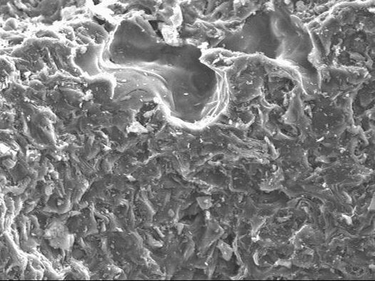 Scanning electron microscope image showing a detailed view of a rough, textured surface at 500x magnification. The image highlights irregular features and microstructures, useful for materials science analysis.