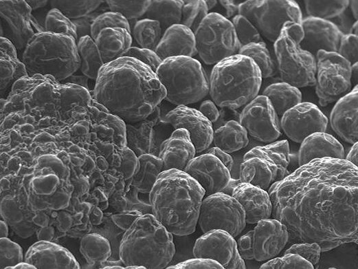 Scanning electron microscope image showing a close-up view of various spherical particles, highlighting their textures and sizes at a magnification of 60,000x. This detailed image is useful for studies in materials science and nanotechnology.