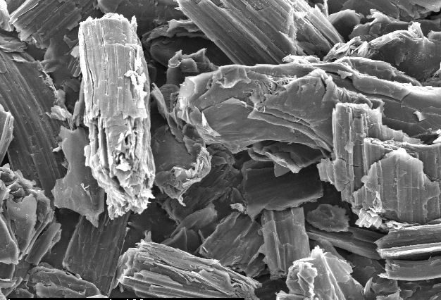 High-resolution scanning electron microscope image of layered mineral particles, showcasing their intricate textures and structures at a magnification scale of 100 micrometers. Ideal for studies in mineralogy and materials science.