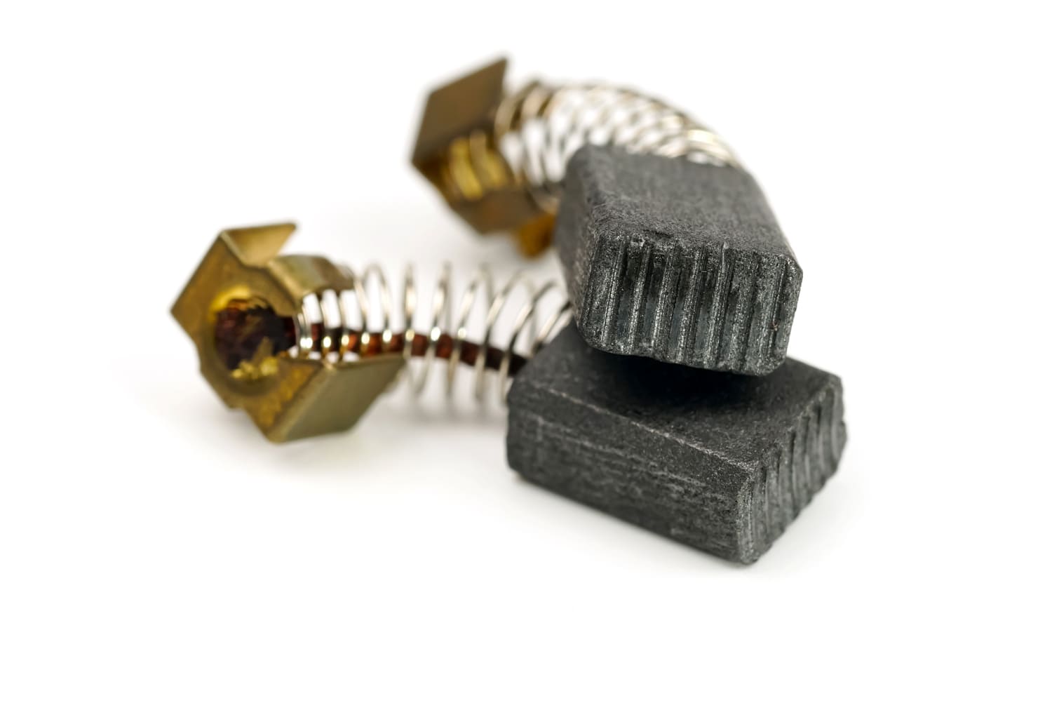 Close-up of motor carbon brushes with metal connectors and springs, commonly used in electric motors and power tools for efficient electrical conductivity and performance.
